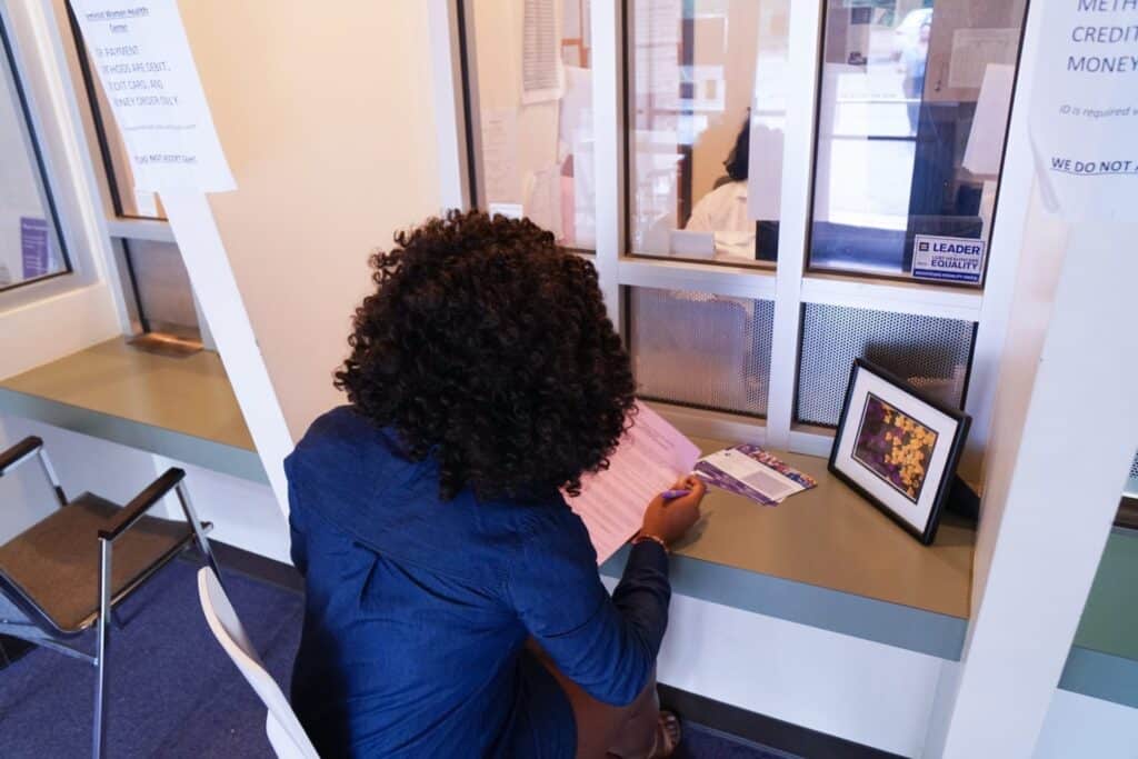 Model posing as patient sitting at front desk.