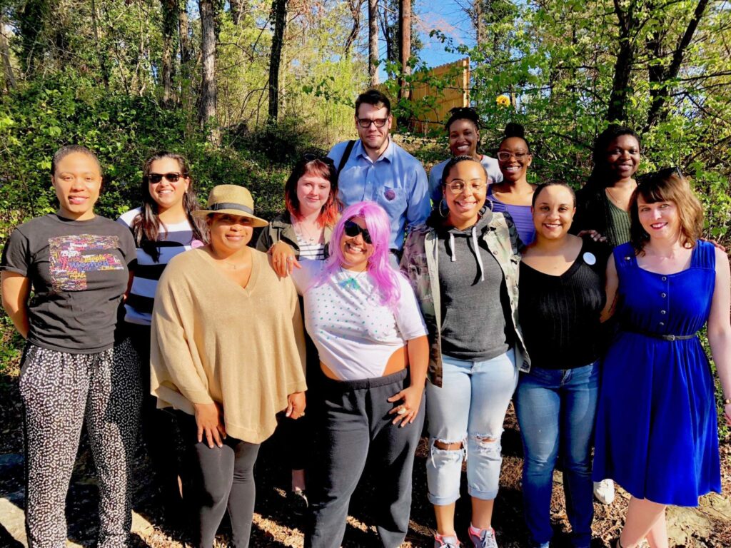 A group of former members of the Errin J. Vuley Fellows Program smile at the camera posing outside.