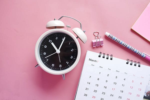 A close-up image of a clock and calendar