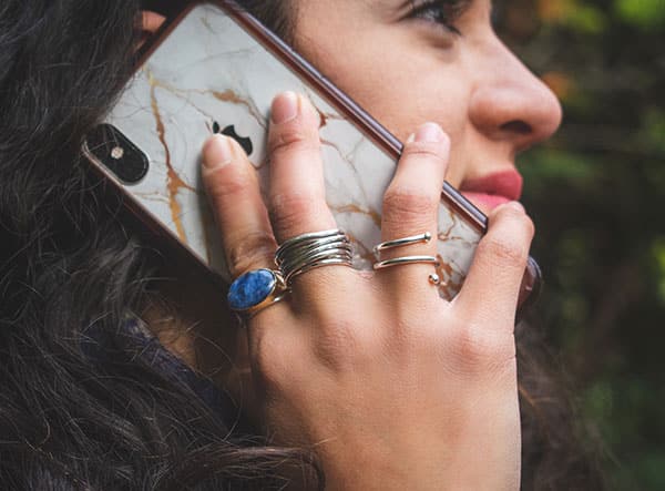 Close-up of model holding cell phone up to her ear.