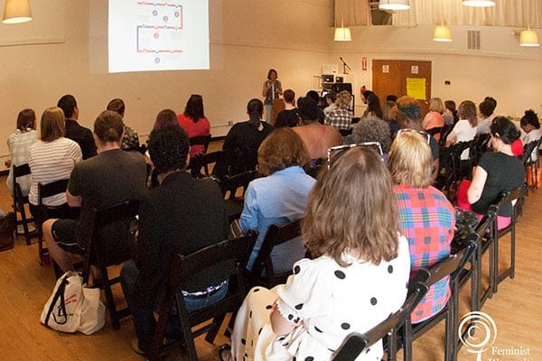 Attendees sit in several rows at a Feminist Women’s Health Center community event.